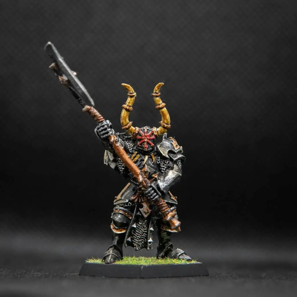 A painted Warhammer warrior miniature with a horned helm and a great axe